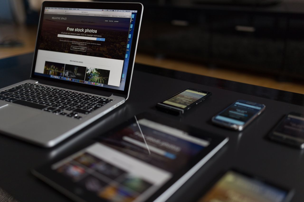 Un espace de travail contemporain mettant en avant un ordinateur portable, une tablette et des smartphones, idéal pour un usage technologique et freelance.
