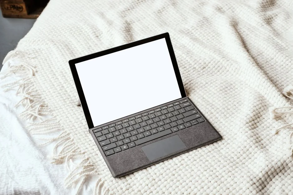 A close-up of a modern workspace, featuring a laptop and smartphone in use.